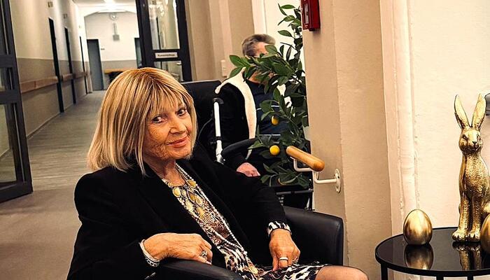 Eine Seniorin lauscht erfreut dem Neustädter Männerchor im Format Klangtreppe Neanderklinik